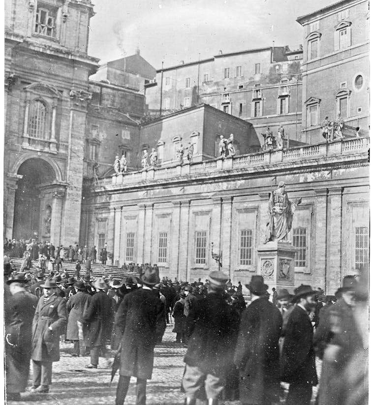 Fotografia em preto e branco: uma multidão em uma praça.